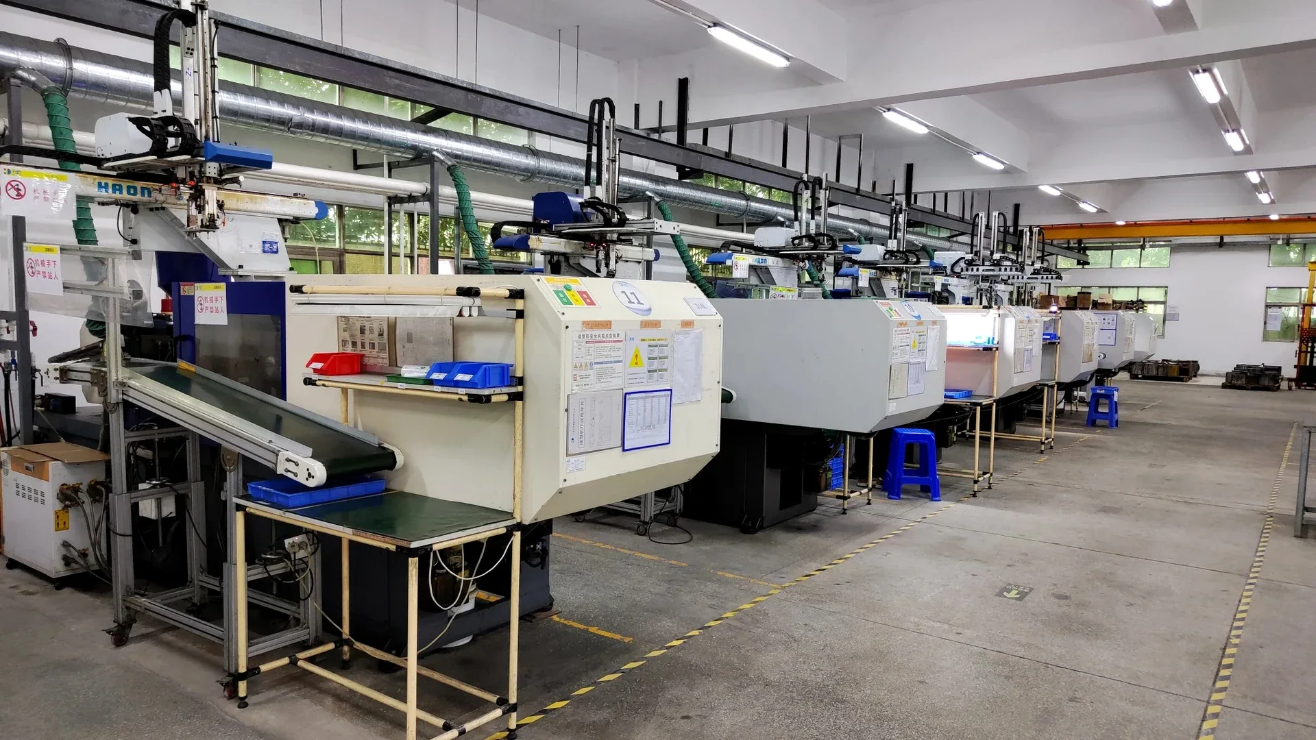MIM injection molding workshop with multiple injection molding machines arranged in a production row